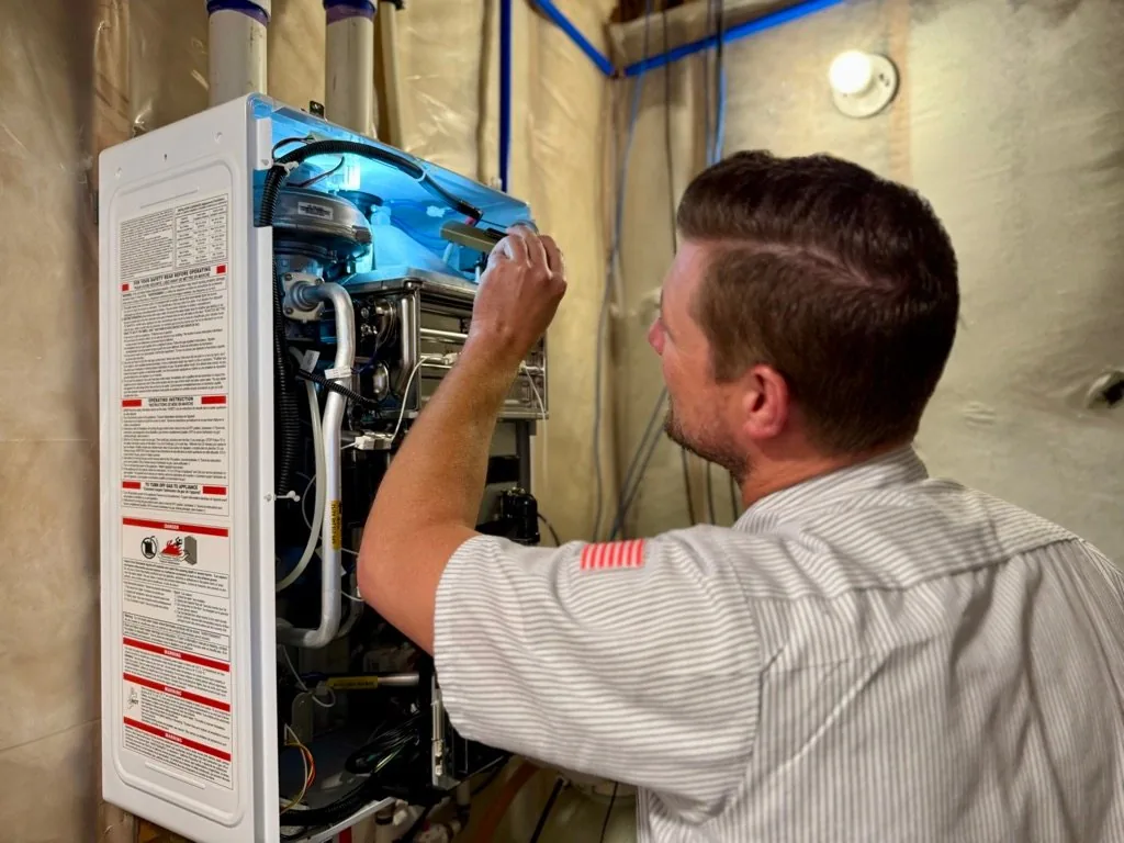 Chris Donahue, Master Plumber and an Owner of Valley Home Plumbing installing a Navien Tankless Water Heater